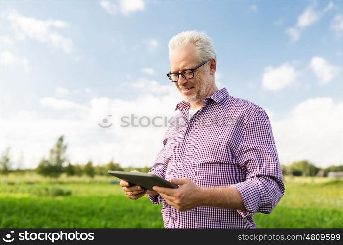 technology, old age and people concept - happy senior man with tablet pc computer at county