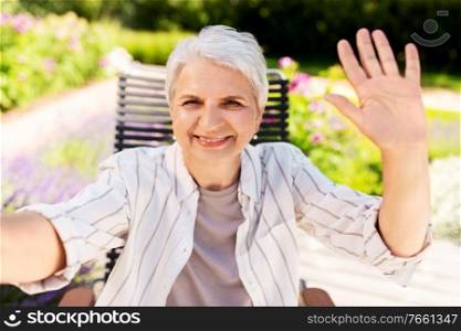 technology, old age and people concept - happy smiling senior woman taking selfie or having video call at summer garden. happy senior woman taking selfie at summer garden