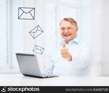 technology, oldness and lifestyle concept - old man in eyeglasses with laptop computer at home showing thumbs up