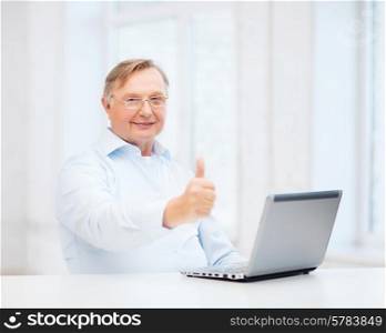 technology, oldness and lifestyle concept - old man in eyeglasses with laptop computer at home showing thumbs up