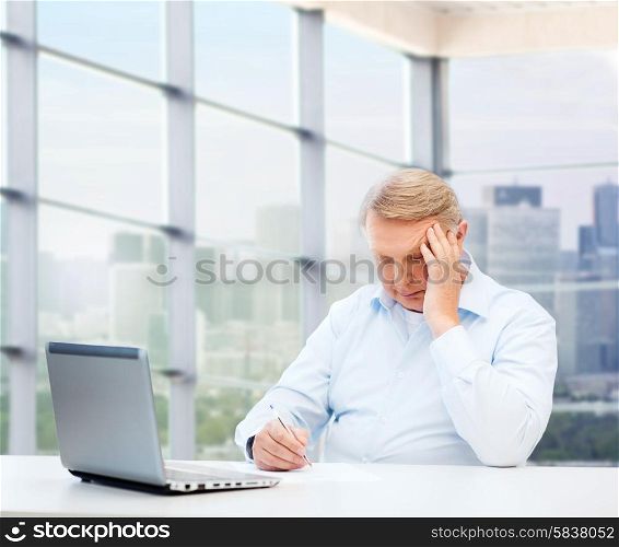technology, oldness and people concept - senior man with laptop and pen writing over office window background