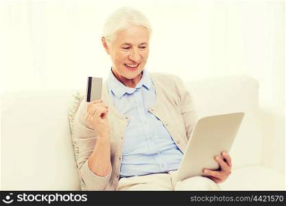 technology, online shopping, age and people concept - happy senior woman with tablet pc computer and credit or bank card at home