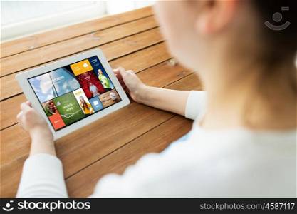 technology, people and advertisement concept - close up of woman with internet news on tablet pc computer screen on wooden table