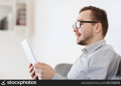 technology, people and distance learning concept - happy man working with tablet pc computer at home