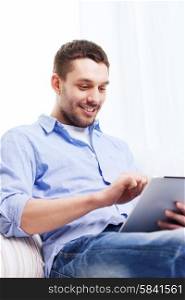 technology, people and leisure concept - smiling young man with tablet pc computer at home