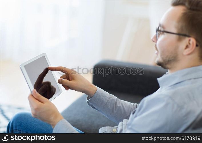 technology, people and lifestyle concept - close up of happy man with tablet pc computer at home