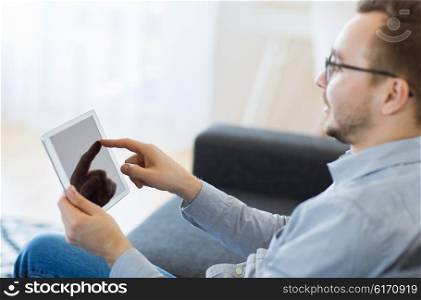 technology, people and lifestyle concept - close up of happy man with tablet pc computer at home