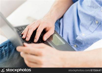technology, people and lifestyle concept - close up of male hands typing on laptop computer keyboard at home