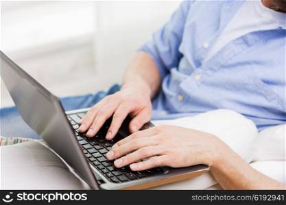 technology, people and lifestyle concept - close up of male hands typing on laptop computer keyboard at home