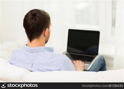 technology, people and lifestyle concept - close up of man typing on laptop computer at home