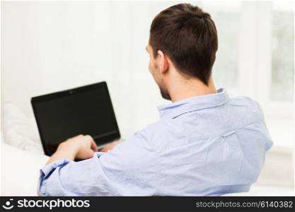 technology, people and lifestyle concept - close up of man typing on laptop computer at home