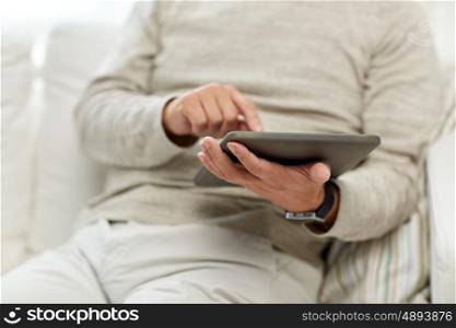 technology, people and lifestyle concept - close up of senior man with tablet pc computer at home