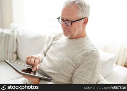 technology, people and lifestyle concept - senior man with tablet pc computer at home