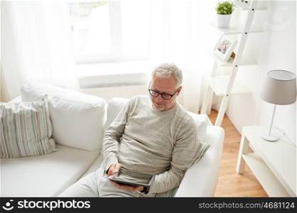 technology, people and lifestyle concept - senior man with tablet pc computer at home