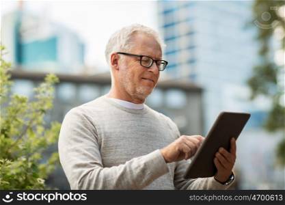 technology, people and lifestyle concept - senior man with tablet pc on city street