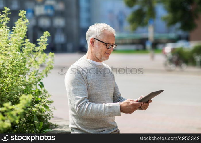 technology, people and lifestyle concept - senior man with tablet pc on city street. senior man with tablet pc on city street