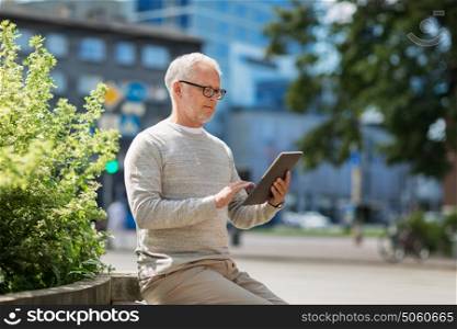 technology, people and lifestyle concept - senior man with tablet pc on city street. senior man with tablet pc on city street