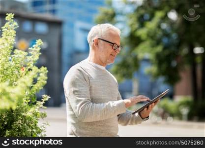 technology, people and lifestyle concept - senior man with tablet pc on city street. senior man with tablet pc on city street