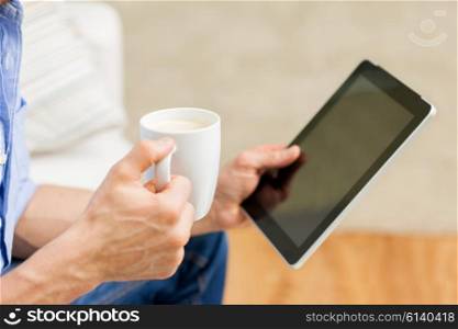 technology, people and lifestyle, distance learning concept - happy man with tablet pc computer drinking coffee or tea at home