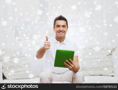 technology, people and lifestyle, distance learning concept - happy man working with tablet pc computer at home over snow effect