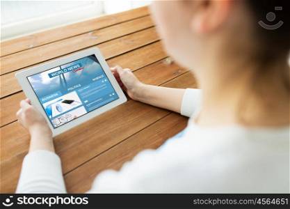 technology, people and mass media concept - close up of woman with world news web page on tablet pc computer screen on wooden table