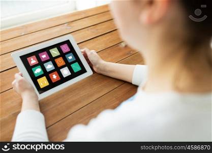 technology, people and media concept - close up of woman with menu icons on tablet pc computer screen on wooden table