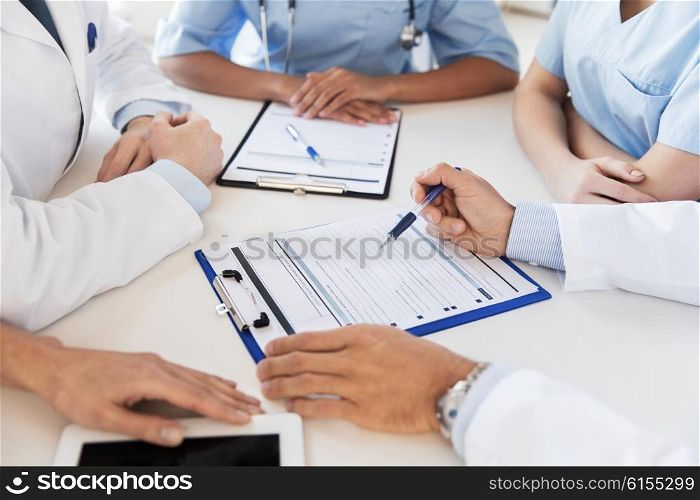 technology, people and medicine concept - close up of doctors with clipboards doctors at conference in hospital