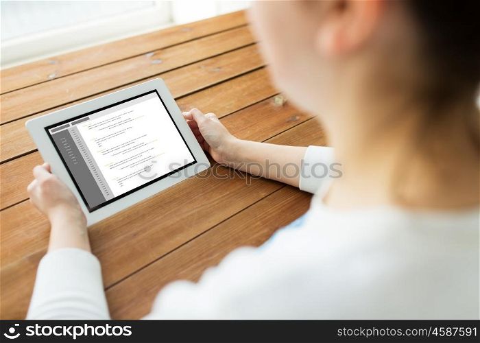 technology, people and programming concept - close up of woman with coding on tablet pc computer screen on wooden table
