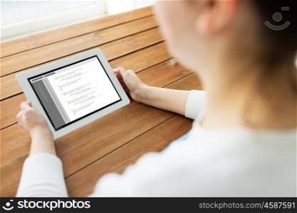technology, people and programming concept - close up of woman with coding on tablet pc computer screen on wooden table