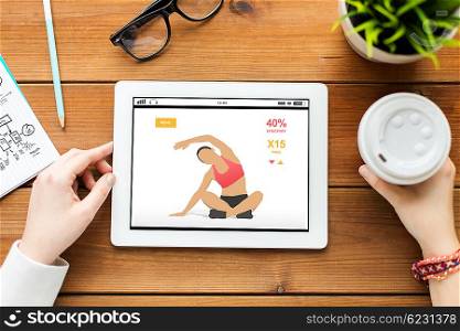 technology, people and sport concept - close up of woman with fitness application on tablet pc computer screen and coffee on wooden table