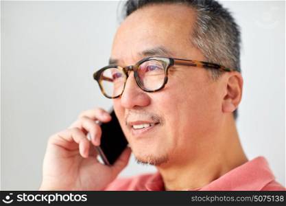 technology, people, lifestyle and communication concept - close up of happy man sitting on sofa calling on smartphone at home. close up of man calling on smartphone at home