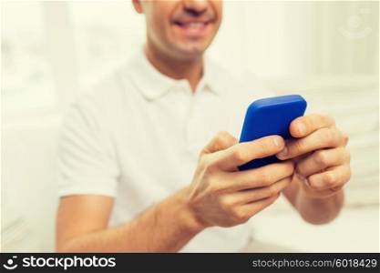 technology, people, lifestyle and communication concept - close up of happy man with smartphone at home
