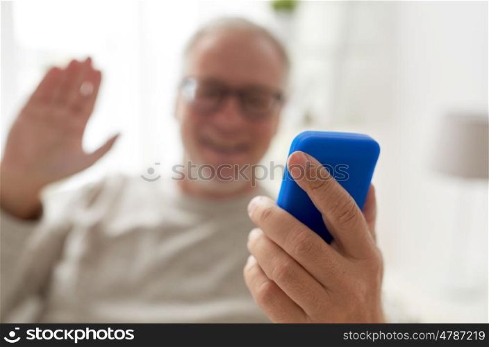 technology, people, lifestyle and communication concept - close up of happy senior man with smartphone having video call at home