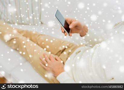 technology, people, lifestyle and communication concept - close up of man with smartphone lying on sofa at home