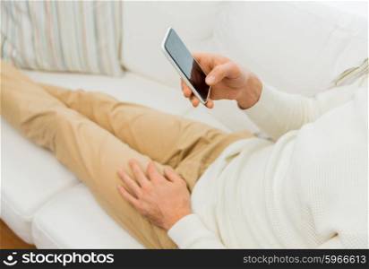 technology, people, lifestyle and communication concept - close up of man with smartphone lying on sofa at home