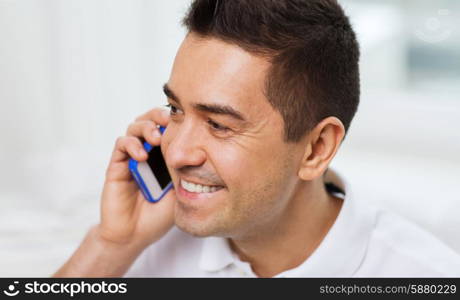 technology, people, lifestyle and communication concept - happy man calling on smartphone at home