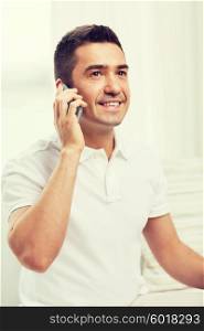 technology, people, lifestyle and communication concept - happy man calling on smartphone at home