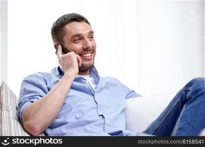 technology, people, lifestyle and communication concept - happy man calling on smartphone at home