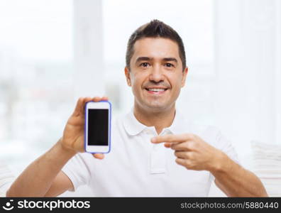 technology, people, lifestyle and communication concept - happy man showing smartphone black blank screen at home