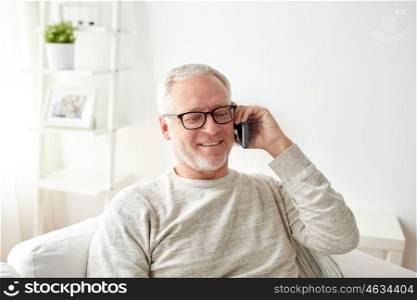 technology, people, lifestyle and communication concept - happy senior man dialing phone number and calling on smartphone at home