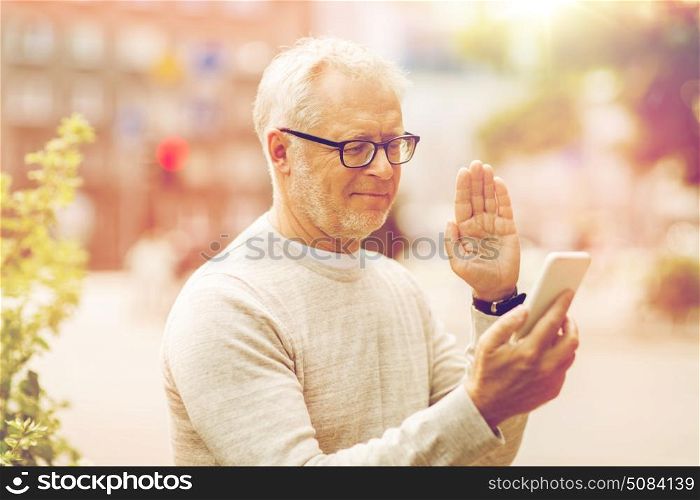 technology, people, lifestyle and communication concept - happy senior man having video call on smartphone in city. senior man having video call on smartphone in city. senior man having video call on smartphone in city