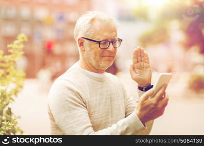 technology, people, lifestyle and communication concept - happy senior man having video call on smartphone in city. senior man having video call on smartphone in city. senior man having video call on smartphone in city