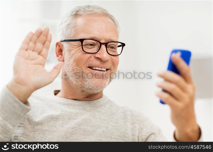 technology, people, lifestyle and communication concept - happy senior man with smartphone having video call at home