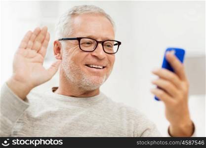 technology, people, lifestyle and communication concept - happy senior man with smartphone having video call at home