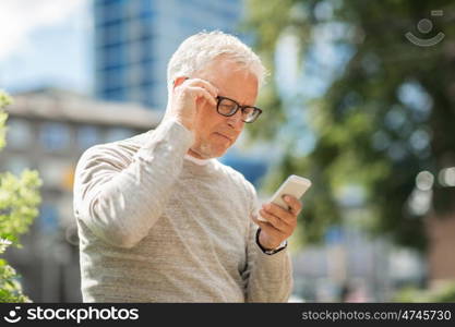 technology, people, lifestyle and communication concept - senior man texting message on smartphone in city