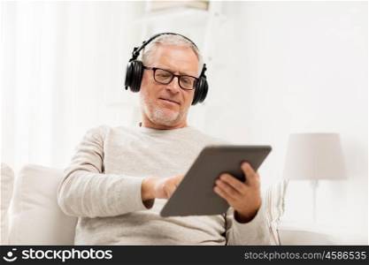 technology, people, lifestyle and distance learning concept - happy senior man with tablet pc computer and headphones listening to music at home