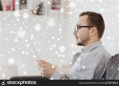 technology, people, winter holidays and christmas concept - happy man with tablet pc computer at home over snow