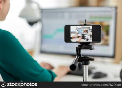 technology, post production and vlog concept - smartphone recording process of woman working in video editor program on laptop computer at home office. smartphone recording woman working in video editor