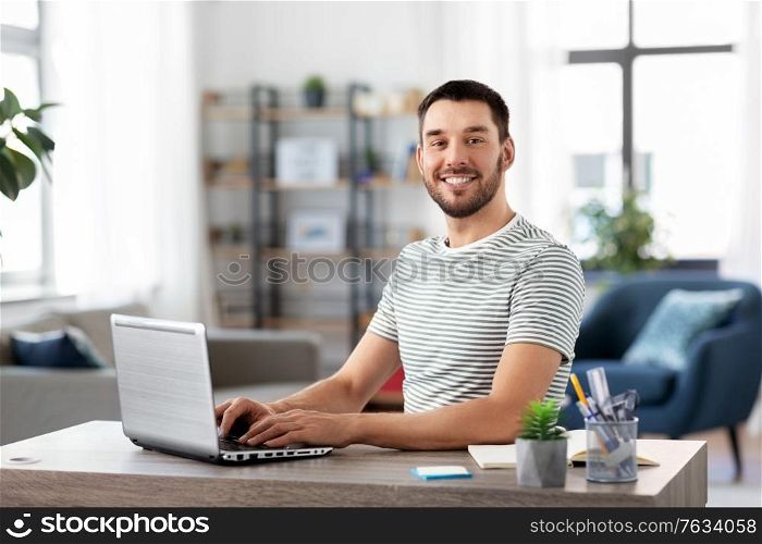 technology, remote job and business concept - man with laptop computer working at home office. man with laptop working at home office