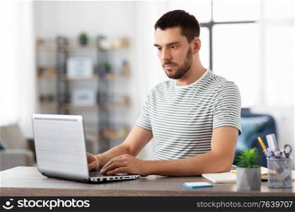 technology, remote job and business concept - man with laptop computer working at home office. man with laptop working at home office